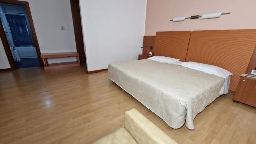 a bedroom with a large white bed and a couch at Bella Italia Palace Hotel in Novara