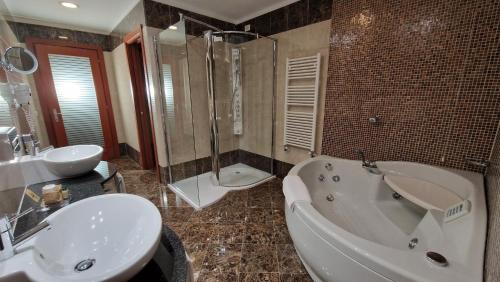 a bathroom with a tub and a sink and a shower at Bella Italia Palace Hotel in Novara