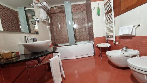 a bathroom with a sink and a tub and a toilet at Bella Italia Palace Hotel in Novara