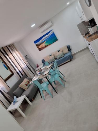 a living room with a couch and a table and chairs at APARTAMENTOS ELEMAR free luggage storage in Málaga