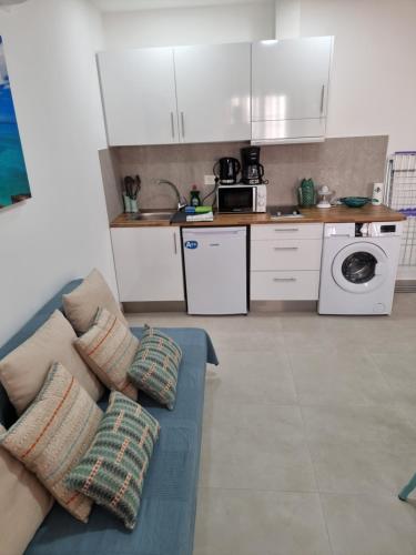 a living room with a couch and a kitchen at APARTAMENTOS ELEMAR free luggage storage in Málaga