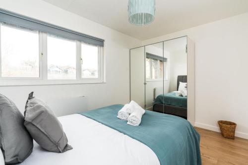- une chambre avec un lit doté d'oreillers et d'un miroir dans l'établissement Sleek and Stylish 2BD Home with a Garden Anerley, à Londres