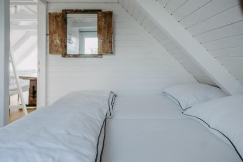 a white room with a bed and a mirror at Seehütte Neusiedlersee inklusive Boot in Rust