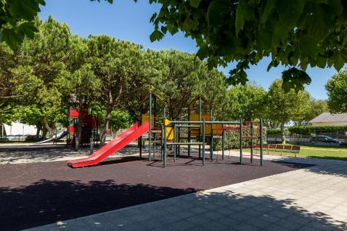 a playground with a red slide in a park at Wave Beach House in Vila do Conde