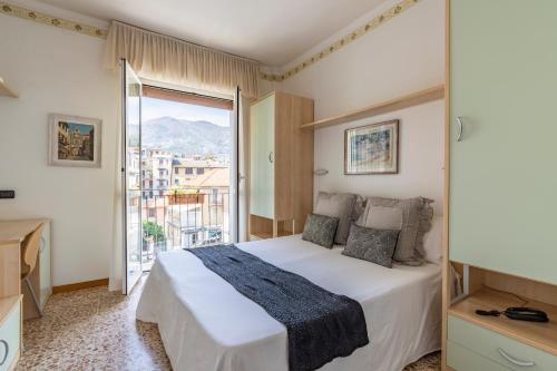 a bedroom with a bed and a large window at Hotel Aida in Alassio