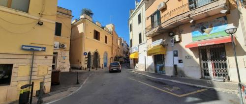 un coche conduciendo por una calle entre edificios en Il Vicolo B&B, en Nettuno