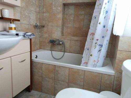 een badkamer met een douche, een toilet en een bad bij “Marko’s Center Beautiful House” in Corfu-stad