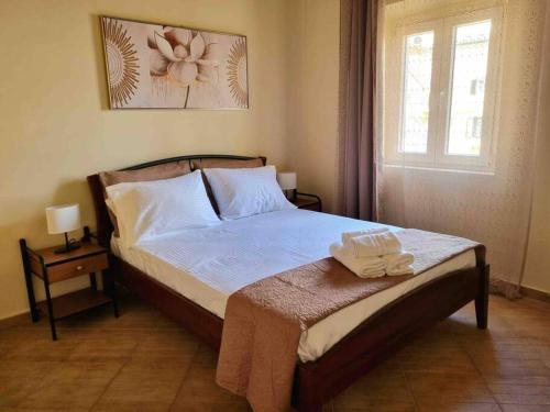 een slaapkamer met een bed met twee handdoeken erop bij “Marko’s Center Beautiful House” in Corfu-stad