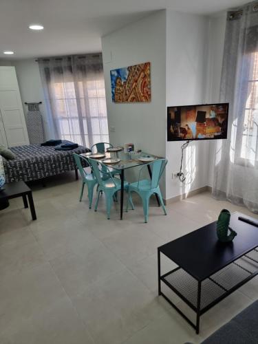 a living room with a table and chairs at APARTAMENTOS ELEMAR free luggage storage in Málaga