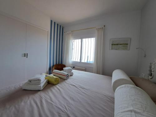 Un dormitorio con una cama blanca con toallas. en La Roqueta Hotel, en Tossa de Mar