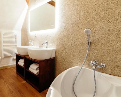 uma casa de banho com uma banheira branca e um lavatório. em DOMAINE DES LUMIERES em Aisonville-et-Bernoville