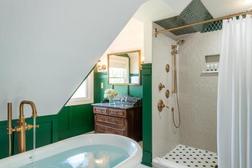 een groene badkamer met een bad en een douche bij Captain Nickels Inn in Searsport