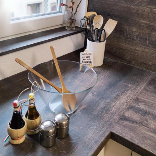 a metal bowl on a counter with bottles and utensils at Im Herzen der Altstadt in Vaihingen an der Enz