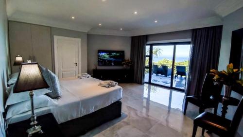 a bedroom with a bed and a view of the ocean at The View Boutique Hotel & Spa in Amanzimtoti