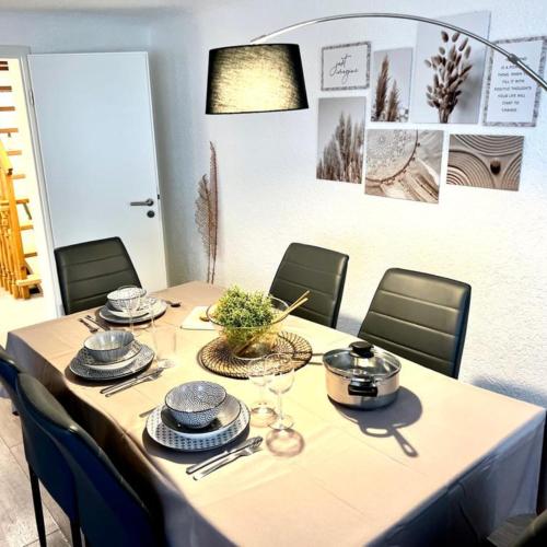 a dining room table with chairs and a table set with dishes at Im Herzen der Altstadt in Vaihingen an der Enz