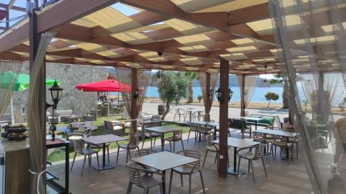 restauracja ze stołami i krzesłami pod drewnianym sufitem w obiekcie AKBÜK TAŞ OTEL w mieście Akbük