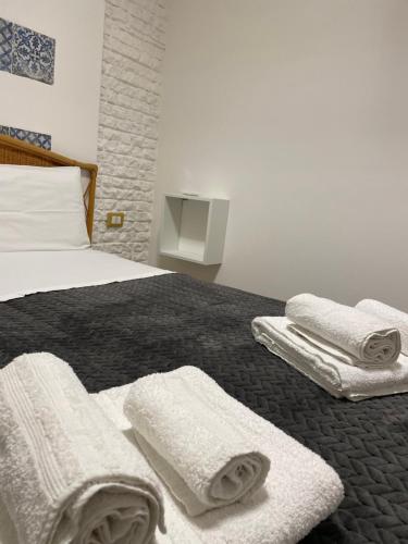 una camera da letto con un letto e asciugamani di Centro Città Basement a Palermo