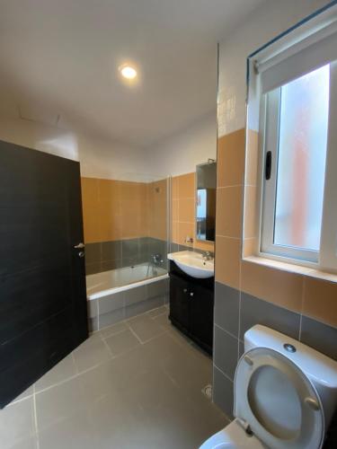 a bathroom with a toilet and a sink and a tub at Best Of Xlendi SeaFront Apartments in Xlendi