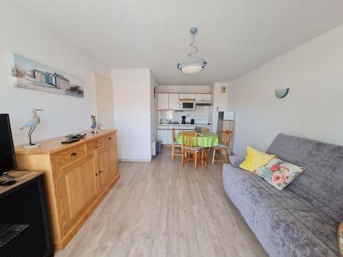 un salon avec un canapé et une cuisine dans l'établissement 2 PIECES RUE DES GENETS, à Saint-Jean-de-Monts