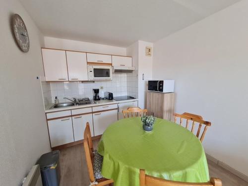 聖讓－德蒙的住宿－2 PIECES RUE DES GENETS，厨房配有一张桌子,上面有绿桌布
