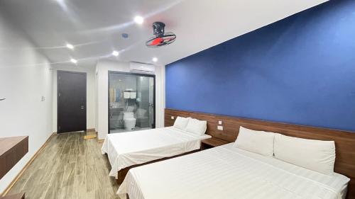 a room with two beds and a blue wall at Thanh Nam Hotel in Dong Quan