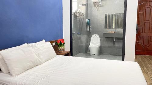 a bedroom with a bed and a bathroom with a toilet at Thanh Nam Hotel in Dong Quan