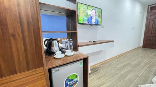 a room with a kitchen with a tv on the wall at Thanh Nam Hotel in Dong Quan