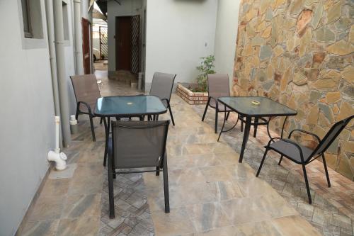 um grupo de mesas e cadeiras numa sala em Coco Palm Bed & Breakfast em Windhoek