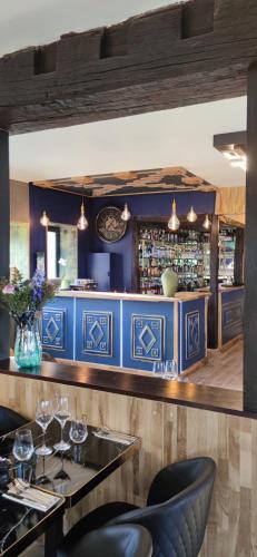 een restaurant met blauwe muren en een bar bij Domaine Malar in Guillerval