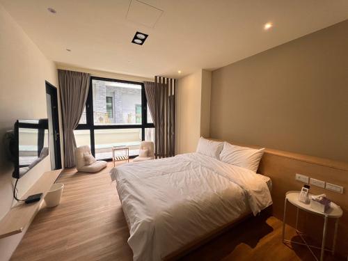 um quarto com uma cama e uma televisão em 懶得棟民宿 em Guanshan