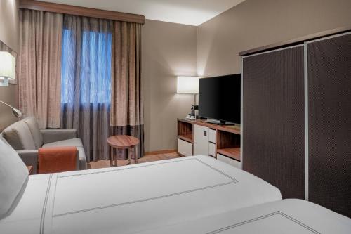a hotel room with a bed and a television at Hotel AC Baqueira Ski Resort, Autograph Collection in Baqueira-Beret
