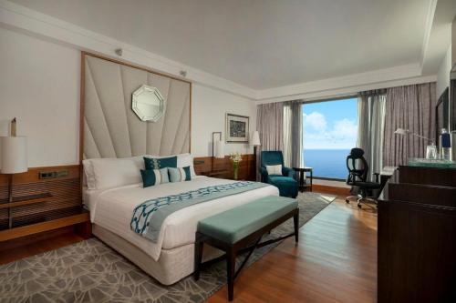 a hotel room with a bed and a large window at InterContinental Marine Drive Mumbai by IHG in Mumbai