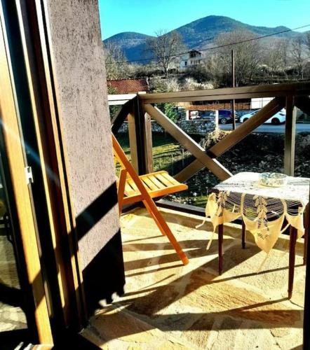 a chair and a table on a balcony at Ενοικιαζόμενη Παραδοσιακή κατοικία Σαν Παραμύθι in Volakas