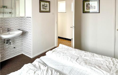 1 dormitorio con cama blanca y lavamanos en Zwaluwnest, en Bergen aan Zee