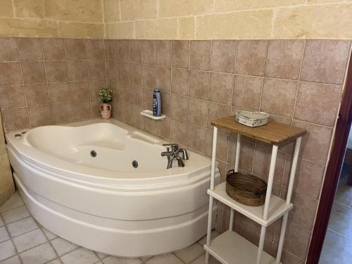 uma banheira na casa de banho com um lavatório em Tal-Mans Farmhouse Gozo em Sannat