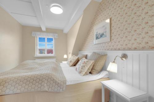 a small bedroom with a bed and a window at Romantic And Charming Holiday Apartment In Lkken in Løkken
