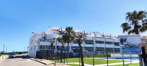 a white building with palm trees in front of it at Casares Cozy Apartment in Casares