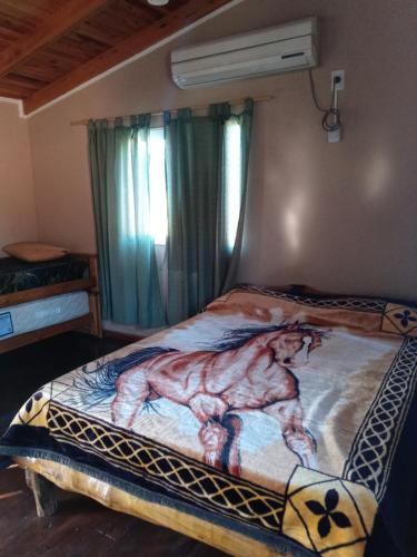 Un dormitorio con una cama con una pintura. en Casa cabaña juanita en Federación