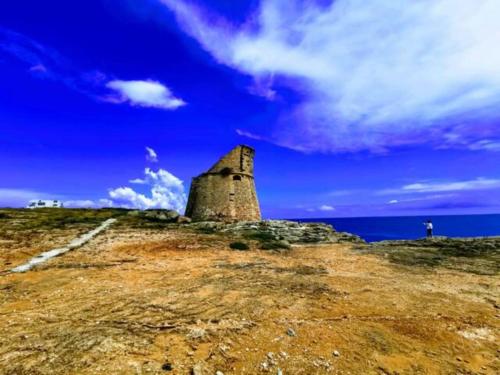 a building on top of a hill with the ocean at Salentum Villa Miami - con ampia terrazza in Vignacastrisi