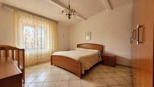 1 dormitorio con cama y ventana en Family Dream MiraMari, en Galtellì
