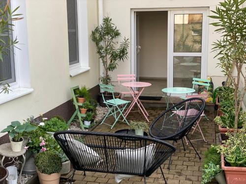 eine Terrasse mit Stühlen, Tischen und Topfpflanzen in der Unterkunft Apartmány Mia Valtice in Valtice