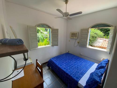 a bedroom with a blue bed and two windows at BUONA SORTE in Lençóis