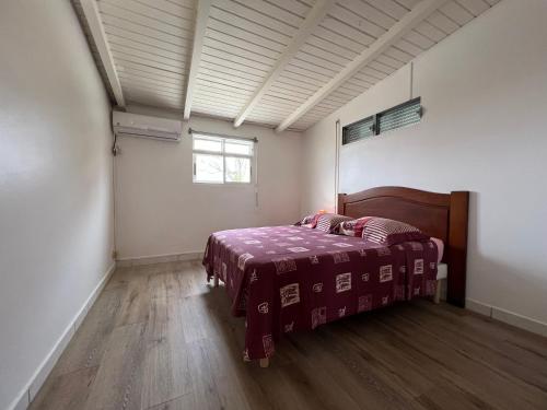 a bedroom with a bed with a purple blanket at Appartement T2 calme, paisible et climatisé à Trois-Rivières in Trois-Rivières
