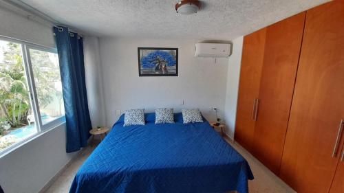 1 dormitorio con cama azul y manta azul en Hermoso Departamento Nuevo, en Acapulco