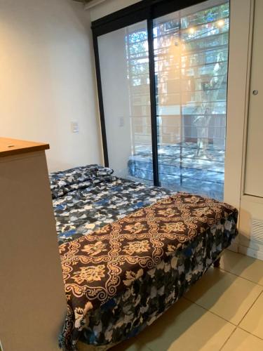 un letto in una camera con una grande finestra di # Crespo Suites # a Rosario