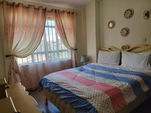 1 dormitorio con cama y ventana en Sweet Homes Apartment Near all Embassies, en Ruaka