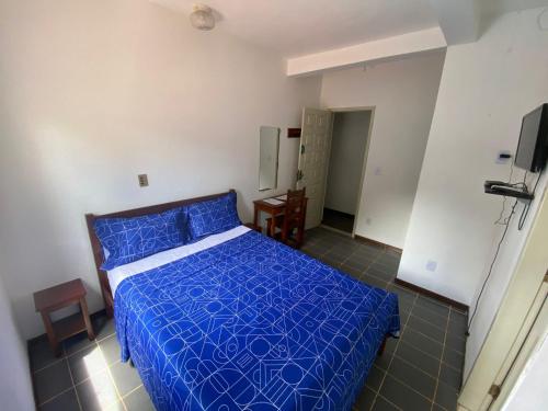 a bedroom with a bed with a blue comforter at BUONA SORTE in Lençóis