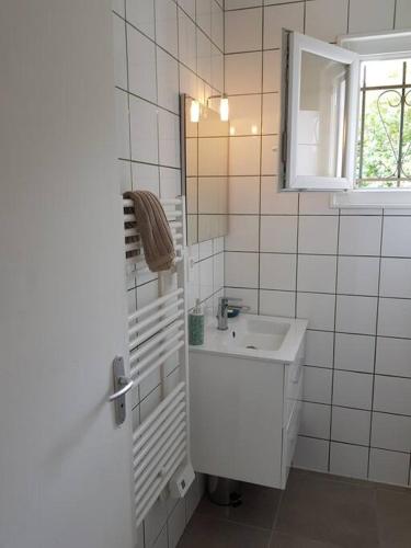 une salle de bain blanche avec un lavabo et un miroir dans l'établissement Beach House avec jardin 200m de la plage, à La Couarde-sur-Mer