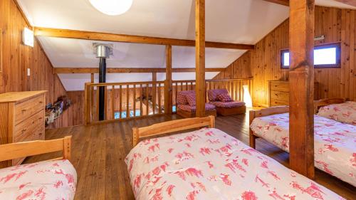 a bedroom with two beds and wooden walls at Les Cochettes -166 - Chalet spacieux 8 pers in Doucy