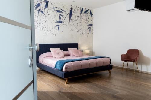 a bedroom with a bed with pink pillows on it at Maison Reale in Foggia